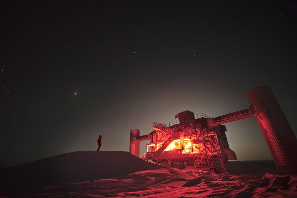 The IceCube neutrino observatory under a night sky at the south pole